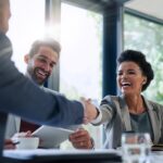 Business women in a meeting shaking a mans hand